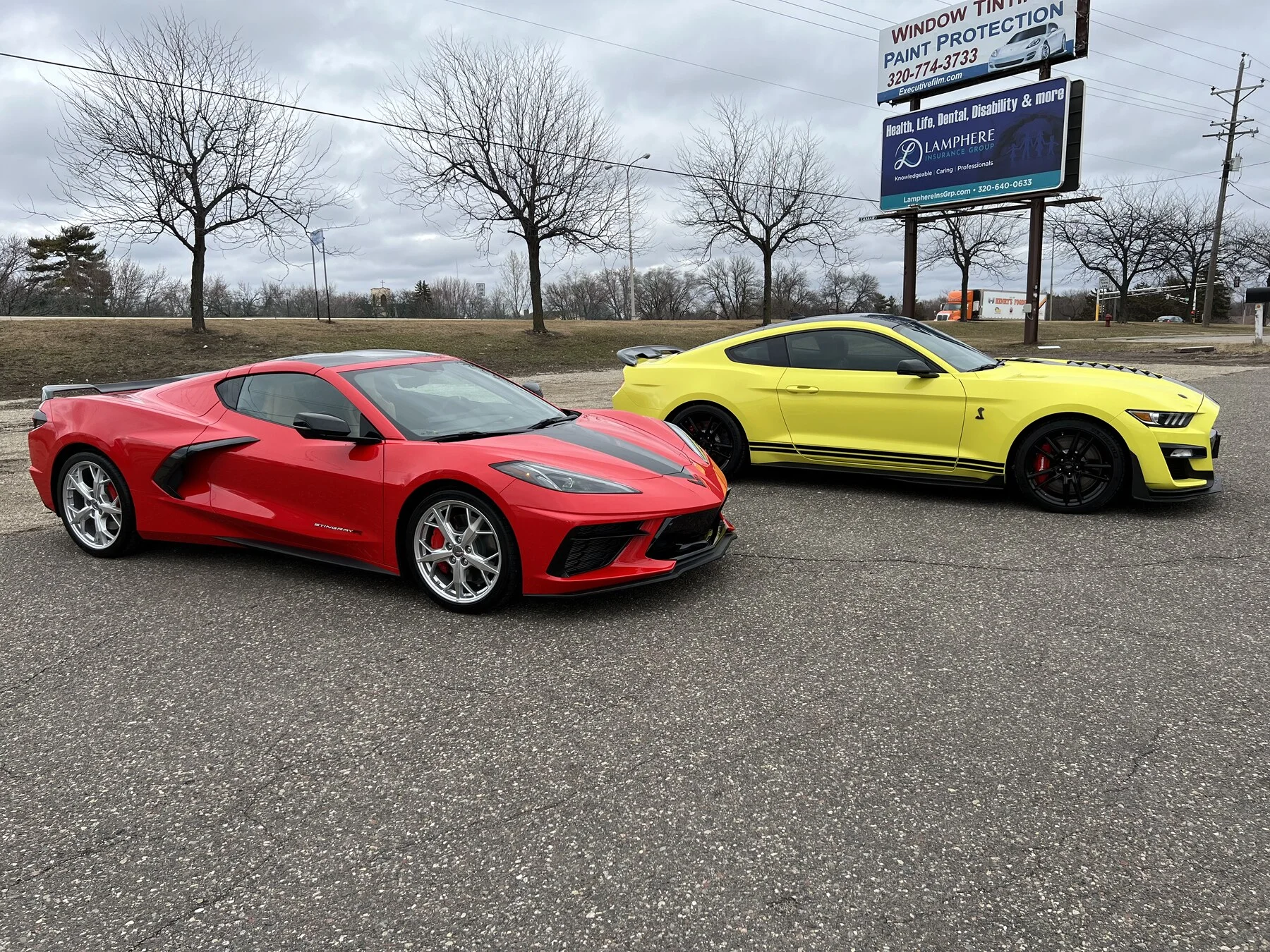 Red Corvette and yellow Camaro outside the shop