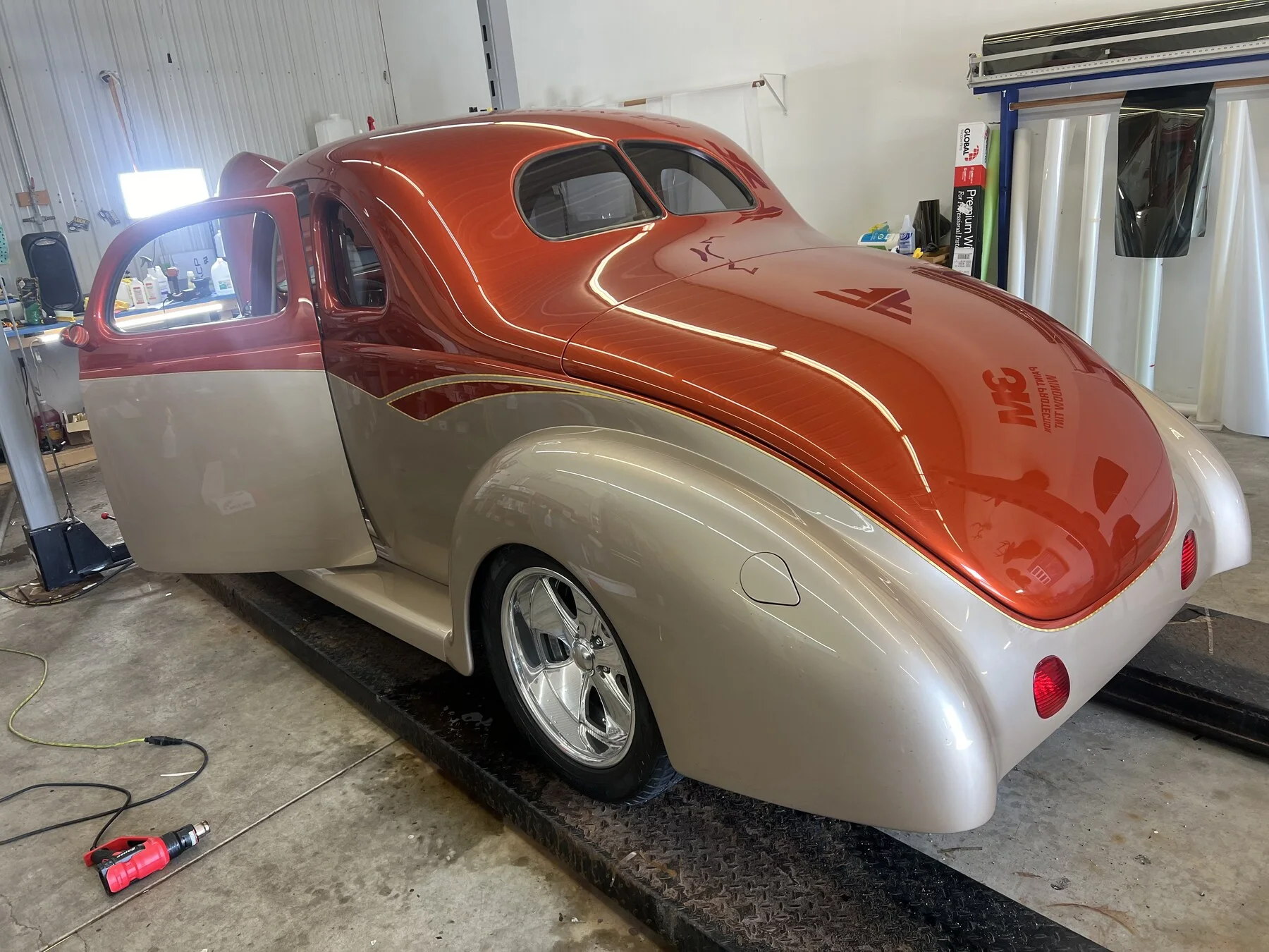 Orange and silver classic street rod inside the workshop