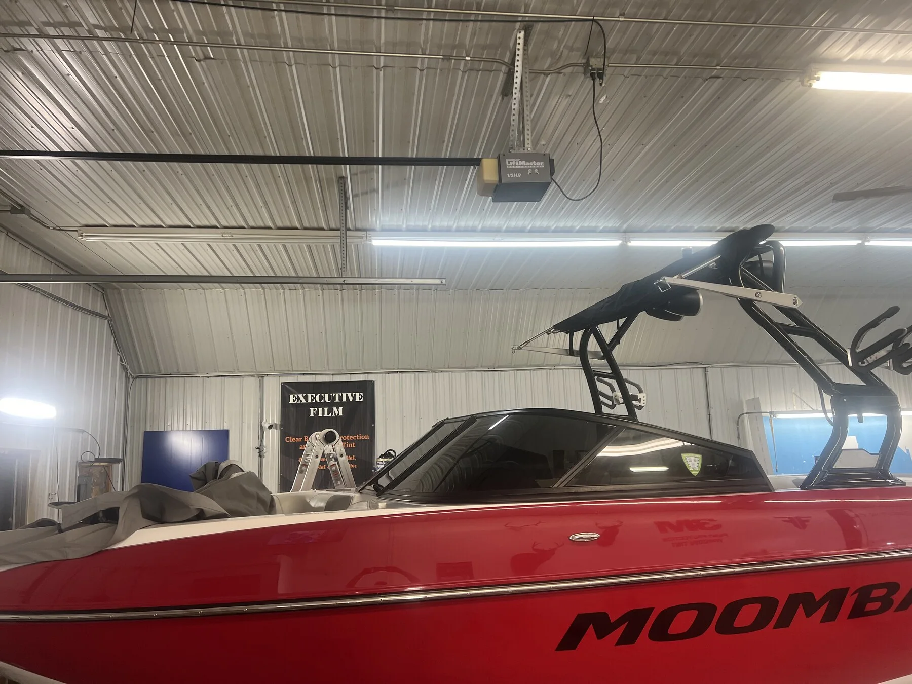 Red Moomba boat with a dark windshield inside the shop